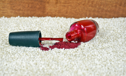 Spilled red nail polish on white carpet