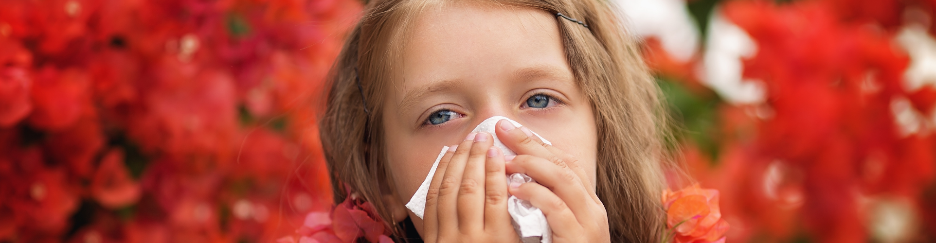 Young girl blowing her nose