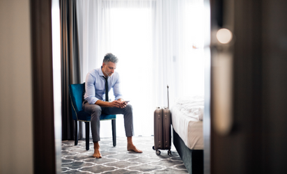 Hotel room wit man sitting on blue chair